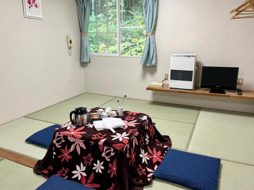 a room with a table in the middle of a room at 北志賀ライムライト in Shimotakai