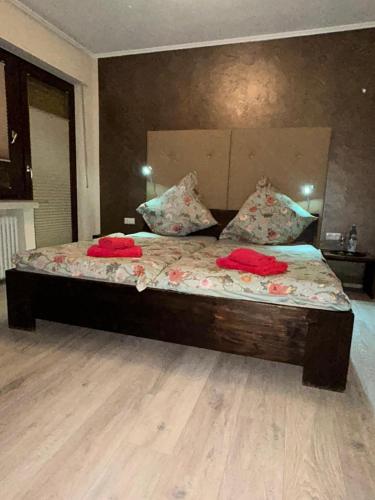 a bedroom with a bed with red pillows on it at Hotel Am Markt in Eschweiler