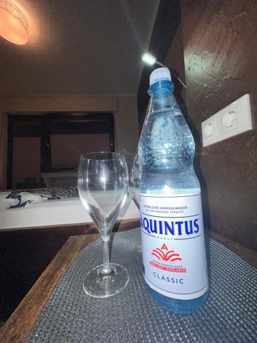 a bottle of water sitting next to a wine glass at Hotel Am Markt in Eschweiler