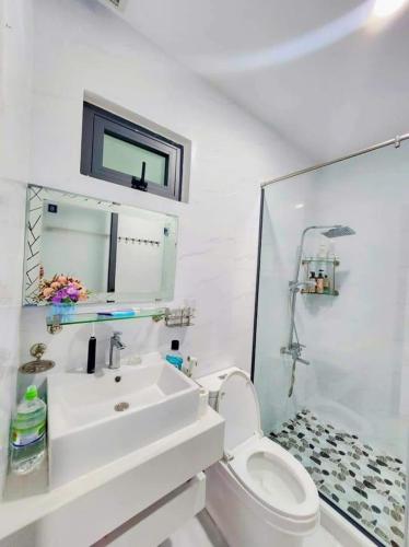 a white bathroom with a sink and a toilet at Apec Sunsea Homestay in Liên Trì (3)