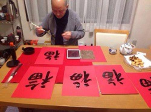 a man sitting at a table with red cards on it at 緑豊かな静かな住宅街の一軒家 東京富春山居 in Higashiyamato