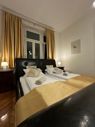 a large bed with a black headboard in a bedroom at Apartment Leyla in Sarajevo