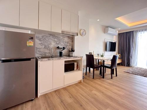 Il comprend une cuisine équipée d'un réfrigérateur et d'une table avec des chaises. dans l'établissement Aristo-2-805, à Ban Lum Fuang