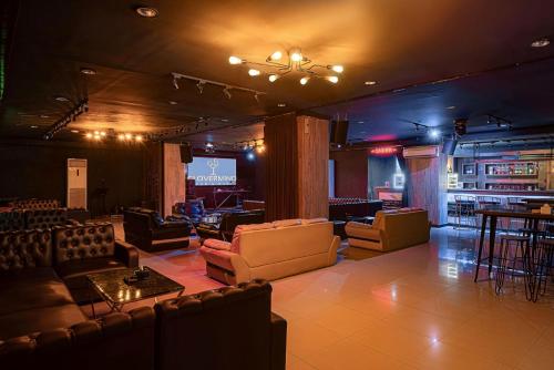 a room with couches and a stage with a bar at Goldvitel Hotel Surabaya in Surabaya