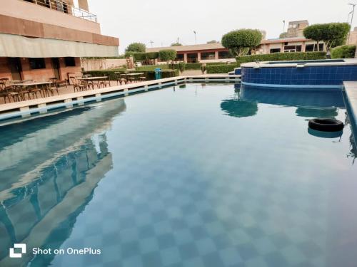 una piscina d'acqua di fronte a un edificio di Apple Resort & Restaurant a Jodhpur