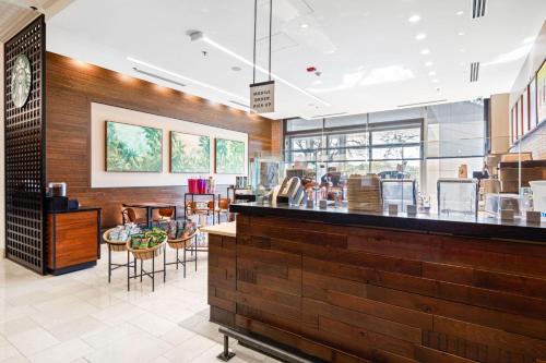 a restaurant with a counter and tables and chairs at Chicago Marriott Naperville in Naperville