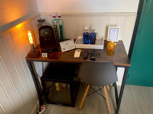 a desk with a chair and a table with bottles on it at Itinere Rooms in Granada