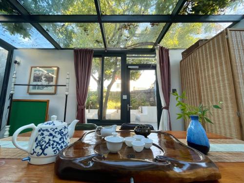 a living room with a table with a vase and cups on it at Waiting for the Blossoms B&B Tea House in Shantou