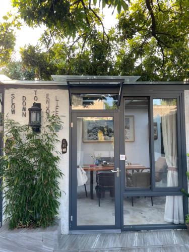 a garden room with a door and a table at Waiting for the Blossoms B&B Tea House in Shantou