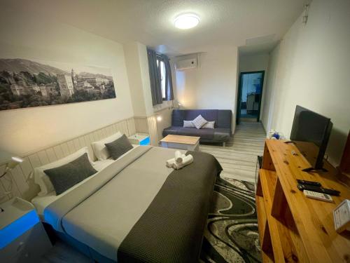 a bedroom with a large bed and a couch at Itinere Rooms in Granada