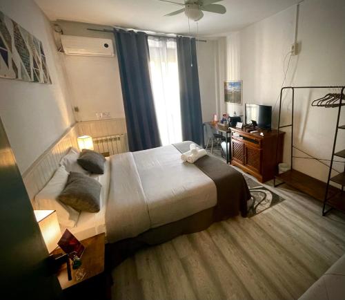 a hotel room with a bed and a desk at Itinere Rooms in Granada