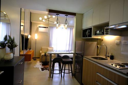 a kitchen with a counter and a table with stools at Amelia's Crib at The Verdin in General Trias