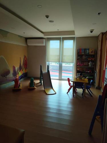 a room with a childrens play area with a slide at Amelia's Crib at The Verdin in General Trias