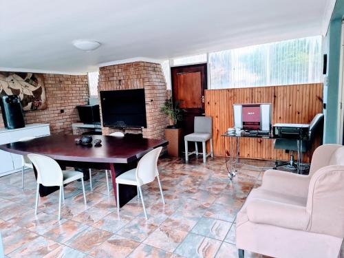 a living room with a table and chairs at 3 bedroom garden house in Tableview in Table View