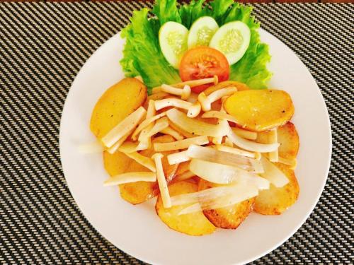 a plate of food with potatoes and vegetables on a table at Sunlight Bungalow in Phu Quoc