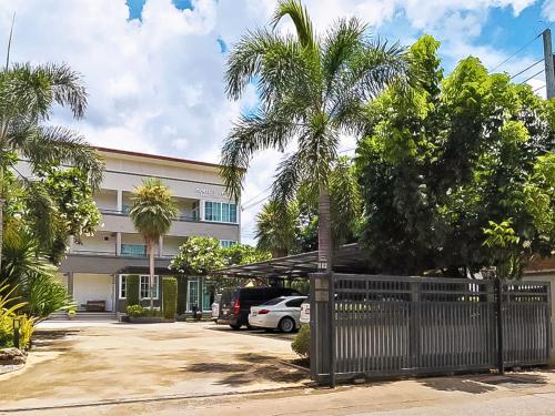 a building with a palm tree in front of a parking lot at T-PARK​ PAKCHONG​ ทีปาร์ค​ ปากช่อง in Pak Chong
