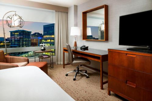 a hotel room with a desk and a television at The Westin Arlington in Arlington