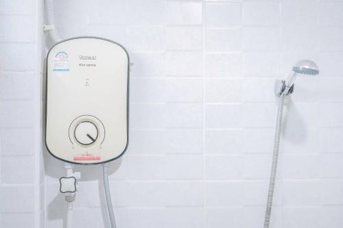 a shower in a bathroom with a white tiled wall at T-PARK​ PAKCHONG​ ทีปาร์ค​ ปากช่อง in Pak Chong