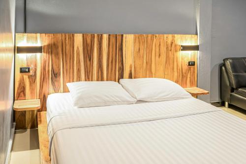 a bedroom with a white bed with a wooden headboard at T-PARK​ PAKCHONG​ ทีปาร์ค​ ปากช่อง in Pak Chong