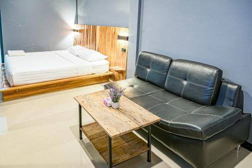 a leather couch and a table in a room with a bed at T-PARK​ PAKCHONG​ ทีปาร์ค​ ปากช่อง in Pak Chong