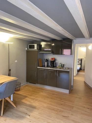 a kitchen with gray cabinets and a table in a room at Esprit-Apart-Hotel in Baden-Baden