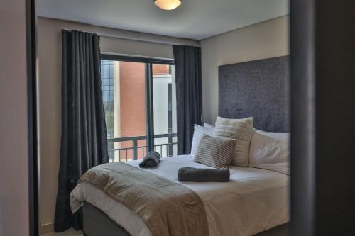 a bedroom with a large bed with a window at The Millennial Cosy stay in Durban