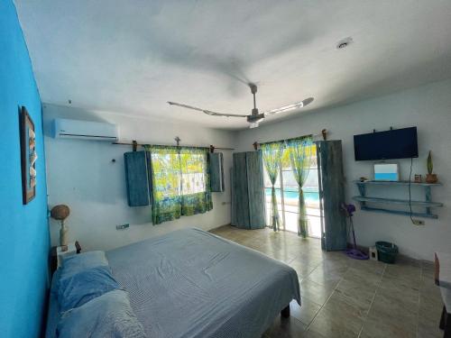 a bedroom with a bed and a large window at Dicha Perfecta Telchac in Telchac Puerto