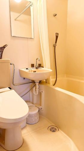 a bathroom with a sink and a toilet and a bath tub at Shiunso in Hakone