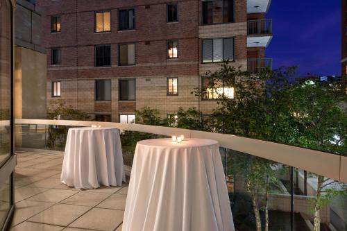two white tables on a balcony with a building at The Westin Arlington in Arlington