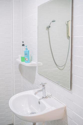 a white bathroom with a sink and a shower at T-PARK​ PAKCHONG​ ทีปาร์ค​ ปากช่อง in Pak Chong