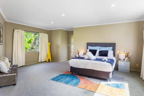 a bedroom with a large bed and a window at Charming Oasis, Your Cozy Retreat Awaits in Auckland
