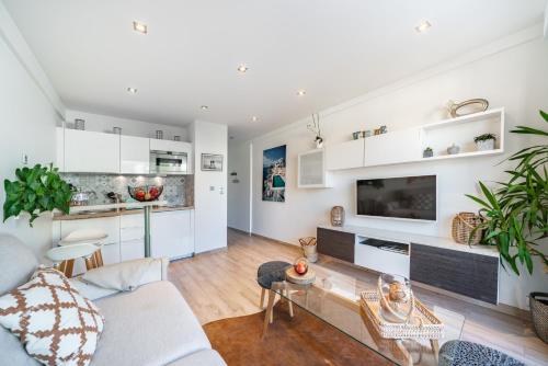 a living room with white cabinets and a tv at STUDIO by the croisette in Cannes