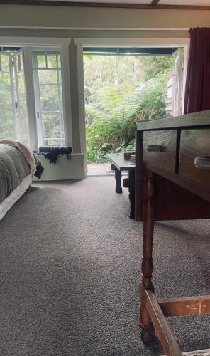 a bedroom with a bed and a dresser and a window at Matakana Waterfall Hideaway in Warkworth