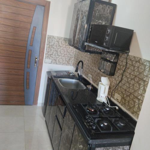 une petite cuisine avec un évier et une cuisinière dans l'établissement Golden Taiba RESORT, à Hurghada
