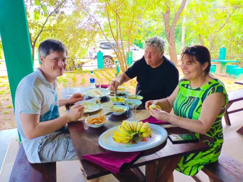 a group of people sitting at a table eating food at Pick Me Village in Dambulla
