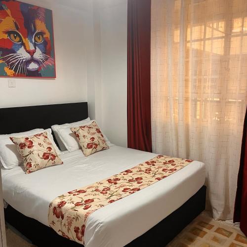a bedroom with a bed with a painting of a cat at Koselig California in Nanyuki