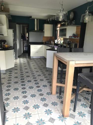 a kitchen with a table and blue and white tiles at Propriété de charme avec piscine intérieure Lille in Marcq-en-Baroeul