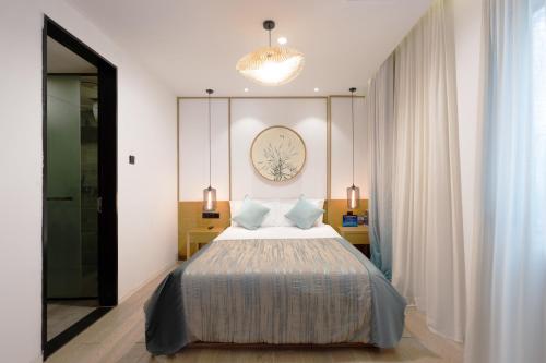 a bedroom with a bed and a chandelier at Meriden M Hotel Beijing - Sanlitun Tuanjiehu Subway Station in Beijing