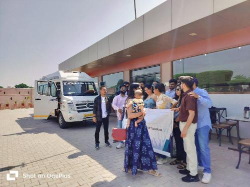een groep mensen die voor een bus staan bij Apple Resort & Restaurant in Jodhpur