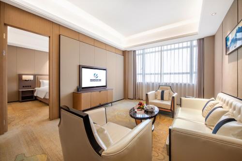 a living room with a couch and a tv at Guangzhou Southern Airlines Pearl Airport Hotel- Free shuttle bus to airport in Guangzhou