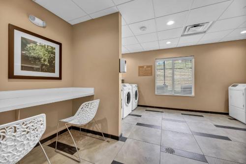a laundry room with two chairs and a washer and dryer at Candlewood Suites - Dumfries - Quantico by IHG in Dumfries