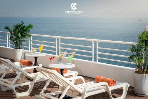 a balcony with tables and chairs on a cruise ship at Catherine Cruise in Ha Long