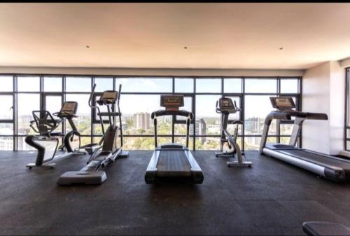 - une salle de sport avec plusieurs tapis de course devant une fenêtre dans l'établissement Escada Studio -501, à Nairobi