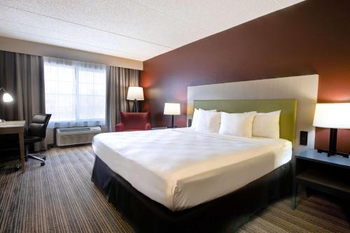 a hotel room with a large bed and a desk at Comfort Inn & Suites St Paul Northeast in Vadnais Heights
