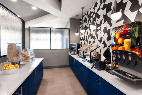 a kitchen with blue cabinets and a counter with fruit on it at La Quinta by Wyndham Greensboro NC in Greensboro