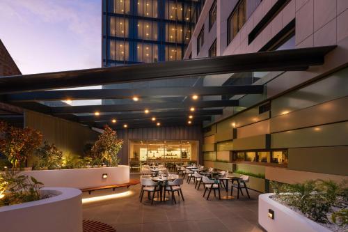 a restaurant with tables and chairs and a building at DoubleTree by Hilton Hobart in Hobart