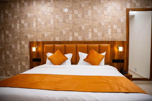 a bedroom with a large bed with orange pillows at Hotel Orange in Bhubaneshwar
