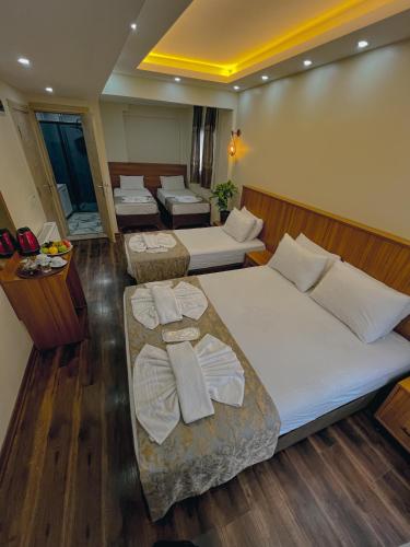 a hotel room with three beds with towels on them at Hotel By Historia in Istanbul