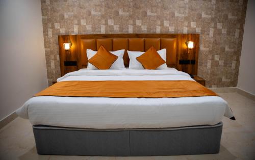 a bedroom with a large bed with orange sheets and pillows at Hotel Orange in Bhubaneshwar