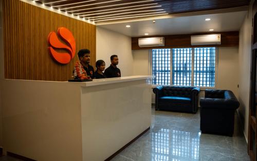 two men sitting at a counter in a lobby at Hotel Orange in Bhubaneshwar